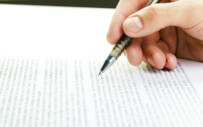 close up of a hand writing on a document