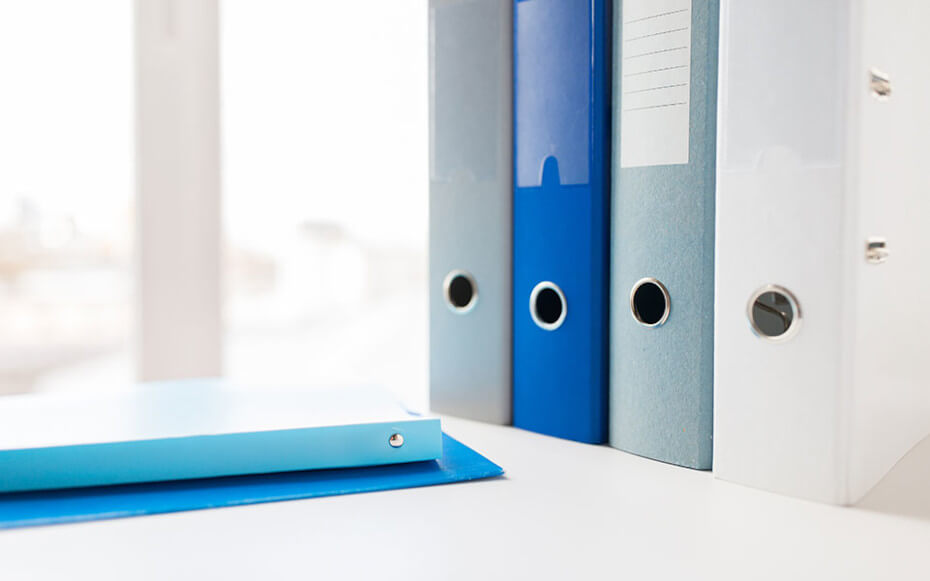 different colored binders on a desk