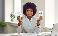 A recruiter holds up two cards, one reading, "no" and one reading, "yes."