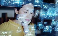 A young woman looks at a series of charts superimposed on a screen.