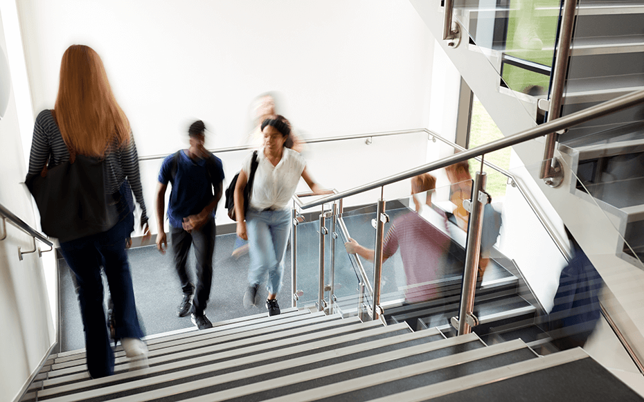 Young professionals ascend a flight of stairs.