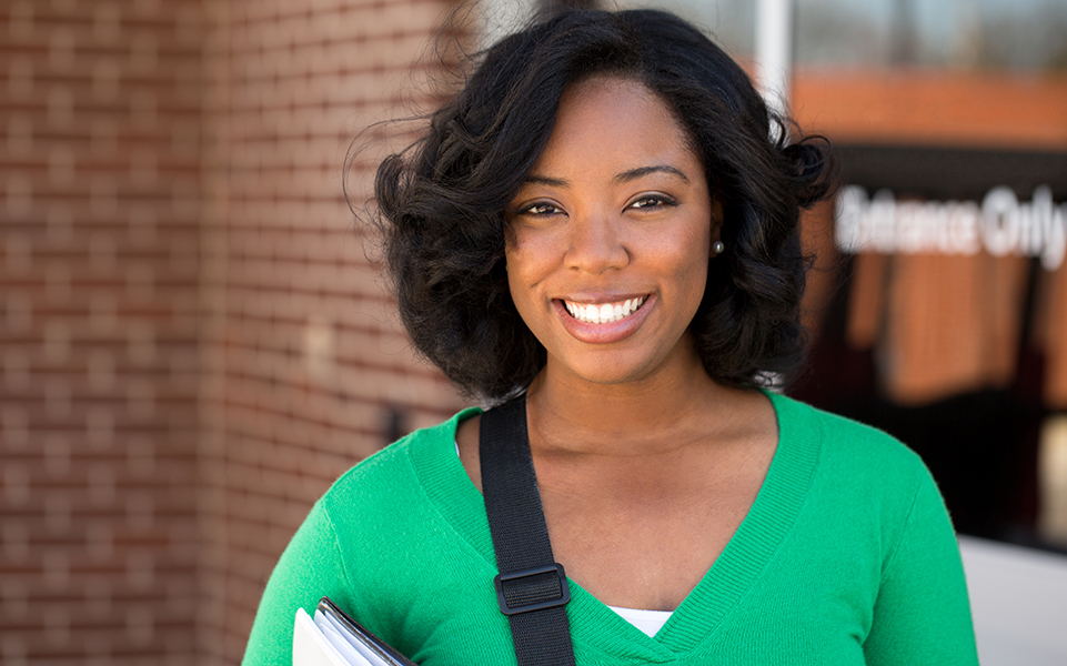 A female, African American student smiles.