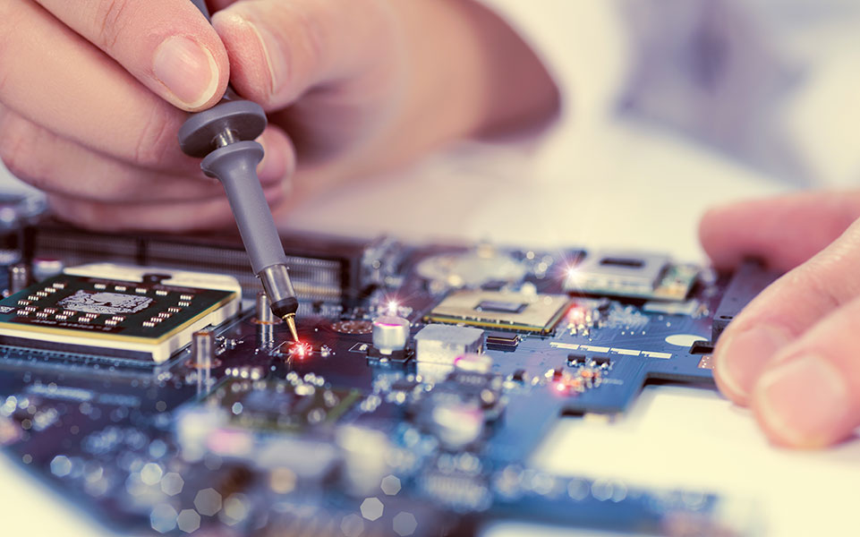 An electrical engineer works on a circuit board.
