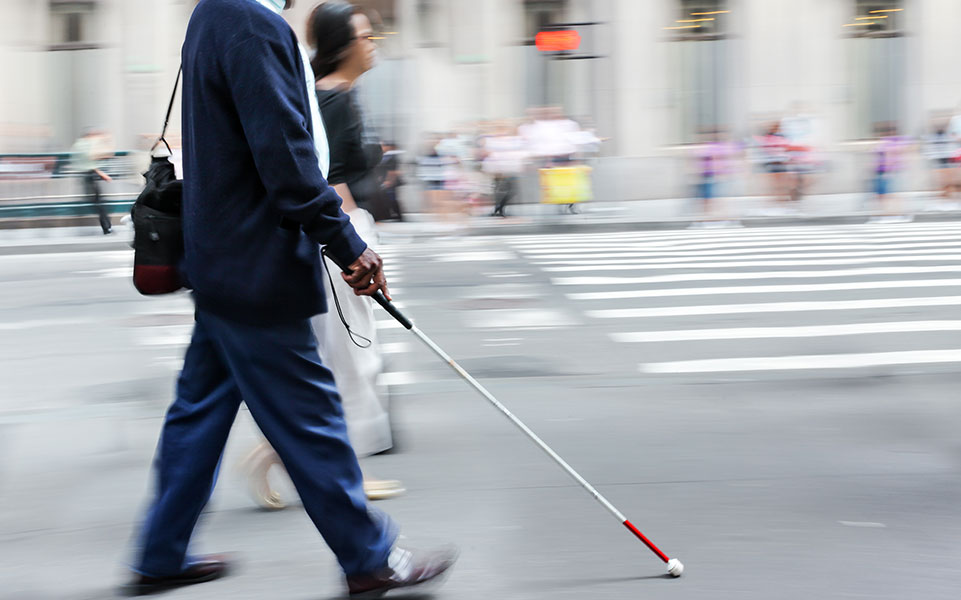 A blind man walks to work.