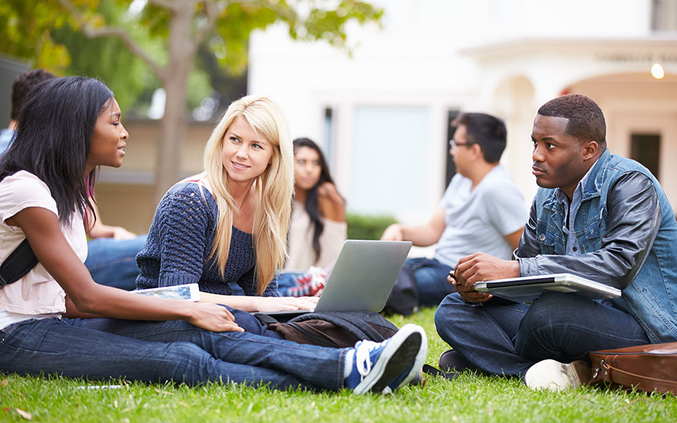 Graduate students sit on campus, discussing life after graduation.