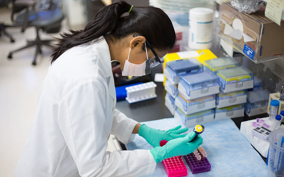 A female biologist fills vials.