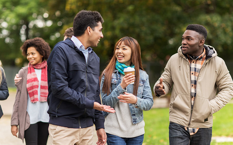 A group of international students walks on campus.
