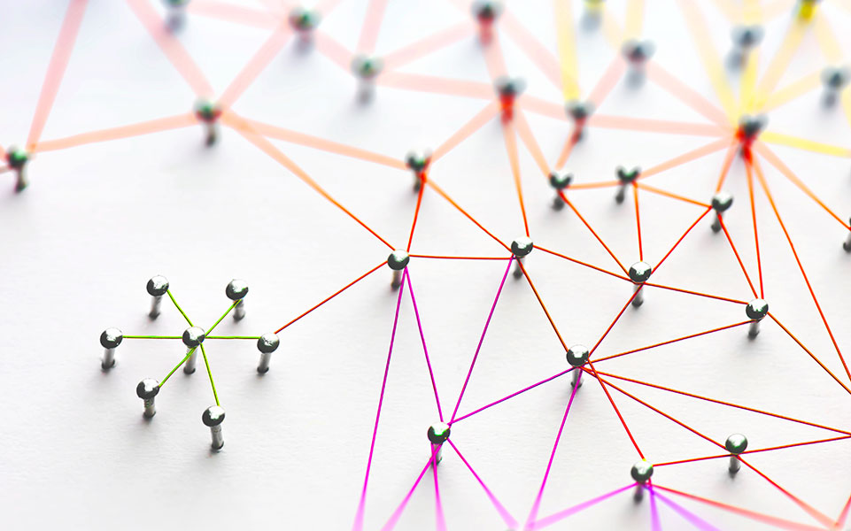 A smaller community of pins connects to a larger community of pins via a colorful string.