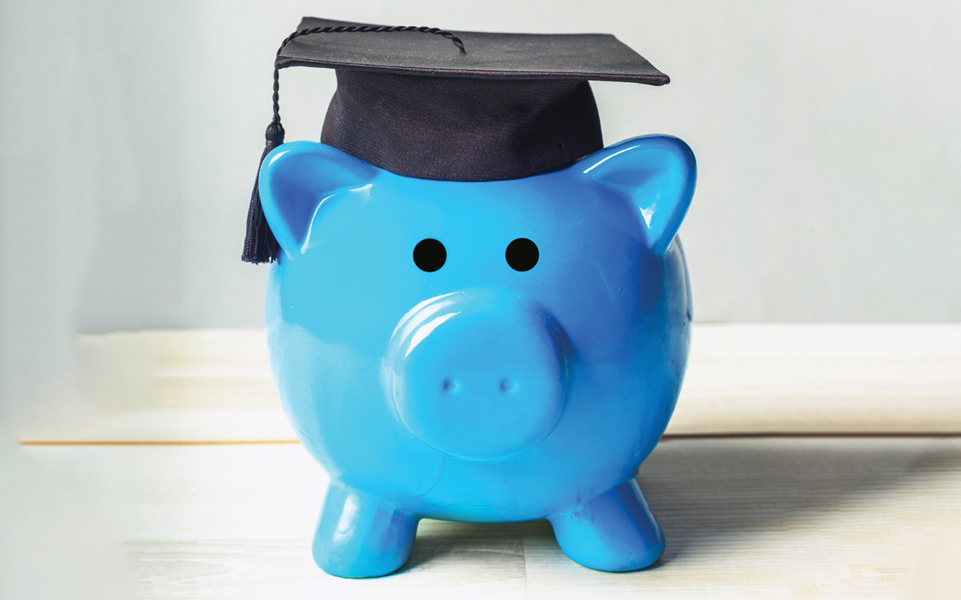 A photo of a blue piggy bank wearing a graduation cap.